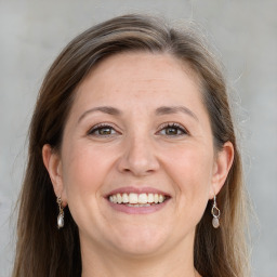 Joyful white adult female with long  brown hair and grey eyes