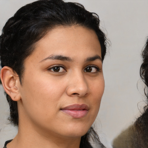 Joyful latino young-adult female with medium  brown hair and brown eyes