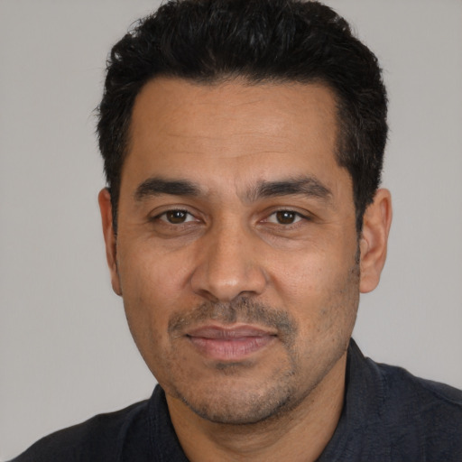 Joyful white adult male with short  black hair and brown eyes