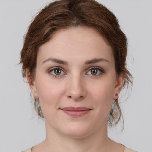 Joyful white young-adult female with medium  brown hair and green eyes