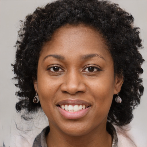 Joyful black young-adult female with medium  brown hair and brown eyes
