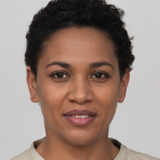 Joyful black young-adult female with short  black hair and brown eyes