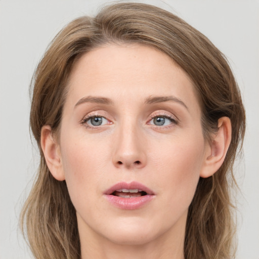 Joyful white young-adult female with long  brown hair and grey eyes