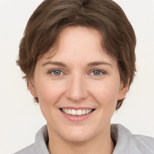 Joyful white young-adult female with short  brown hair and grey eyes