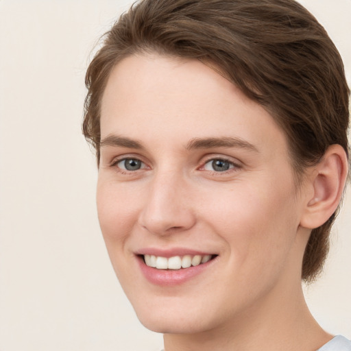 Joyful white young-adult female with short  brown hair and grey eyes