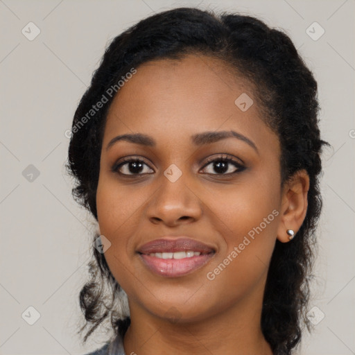 Joyful black young-adult female with long  black hair and brown eyes