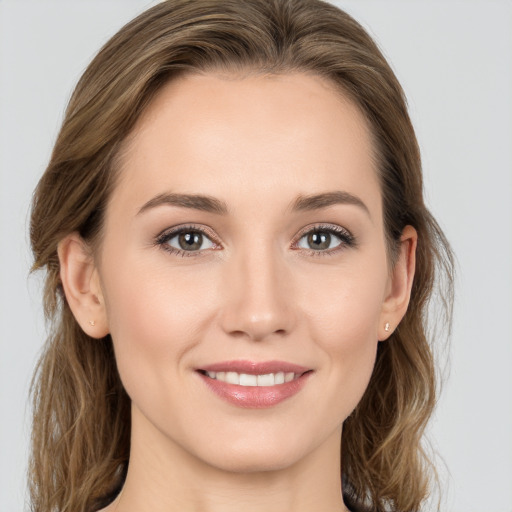 Joyful white young-adult female with long  brown hair and green eyes