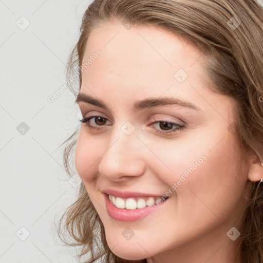 Joyful white young-adult female with long  brown hair and blue eyes