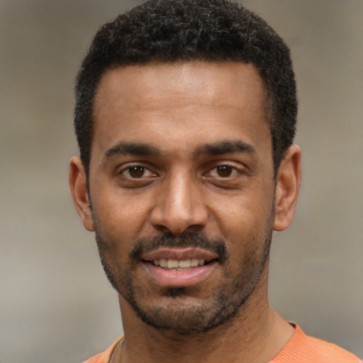 Joyful black young-adult male with short  black hair and brown eyes