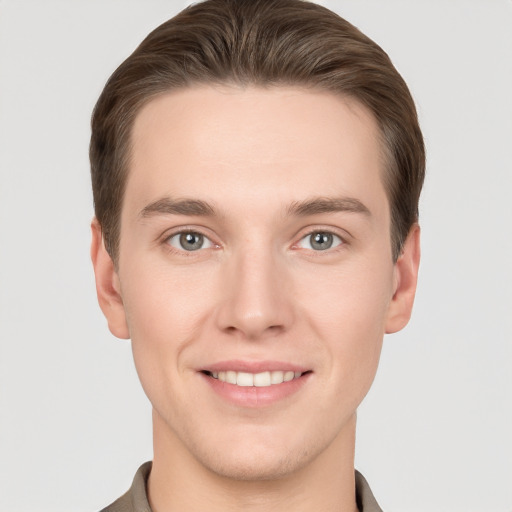 Joyful white young-adult male with short  brown hair and grey eyes