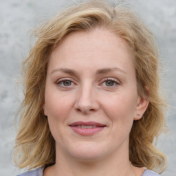 Joyful white young-adult female with medium  brown hair and blue eyes