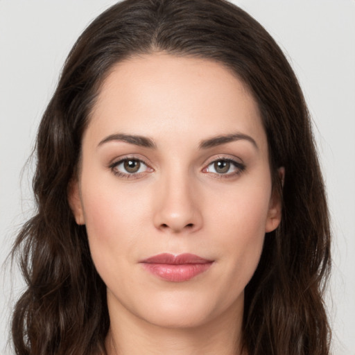 Joyful white young-adult female with long  brown hair and brown eyes