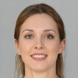 Joyful white young-adult female with medium  brown hair and grey eyes