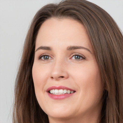 Joyful white young-adult female with long  brown hair and grey eyes