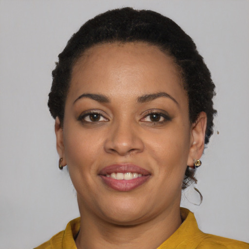 Joyful black young-adult female with short  black hair and brown eyes