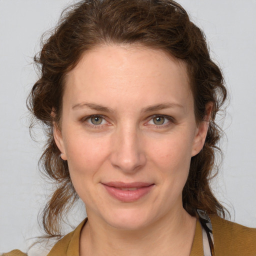 Joyful white young-adult female with medium  brown hair and blue eyes