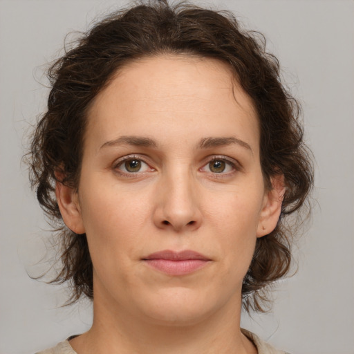 Joyful white young-adult female with medium  brown hair and green eyes