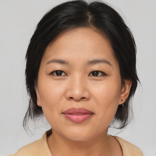 Joyful asian adult female with medium  brown hair and brown eyes