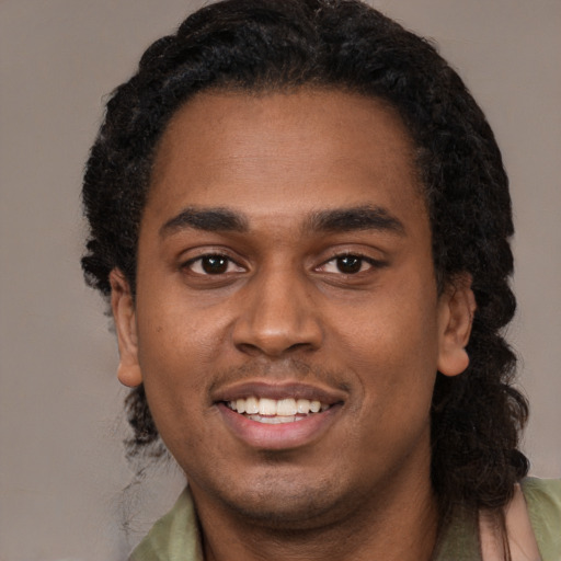 Joyful black young-adult male with short  black hair and brown eyes