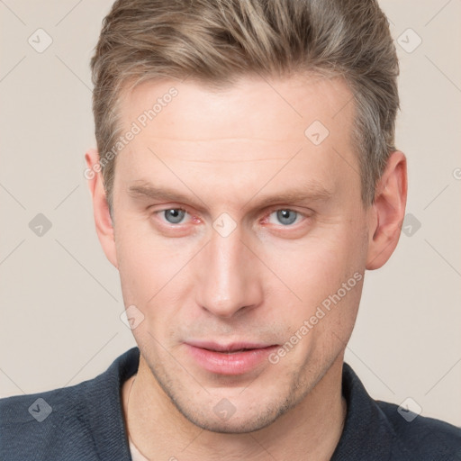 Joyful white young-adult male with short  brown hair and grey eyes