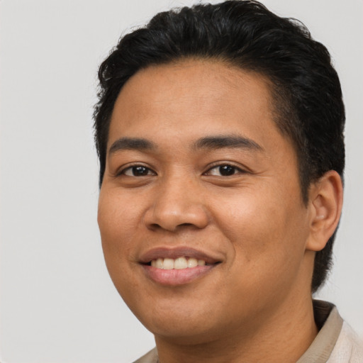 Joyful latino young-adult male with short  brown hair and brown eyes
