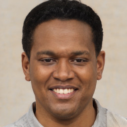 Joyful latino young-adult male with short  black hair and brown eyes