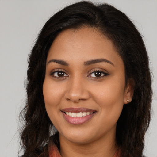 Joyful latino young-adult female with long  brown hair and brown eyes