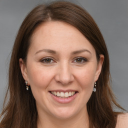 Joyful white adult female with long  brown hair and grey eyes