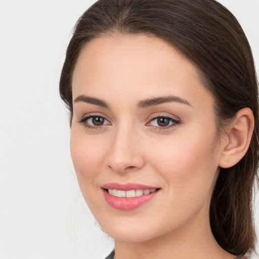 Joyful white young-adult female with long  brown hair and brown eyes