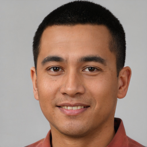Joyful latino young-adult male with short  brown hair and brown eyes