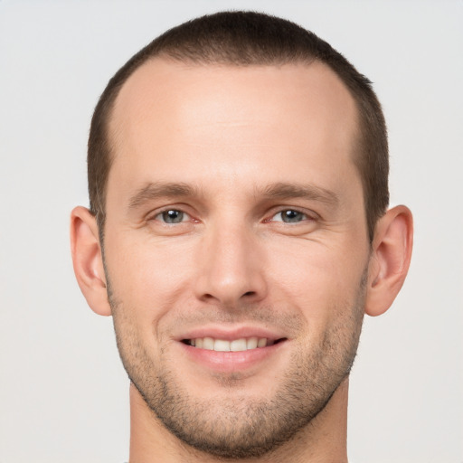 Joyful white young-adult male with short  brown hair and grey eyes