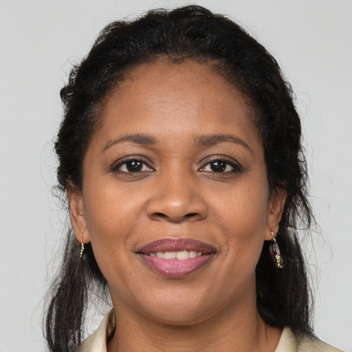 Joyful black young-adult female with long  brown hair and brown eyes
