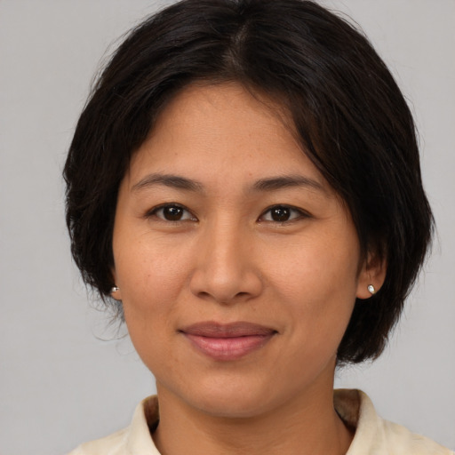 Joyful asian young-adult female with medium  brown hair and brown eyes