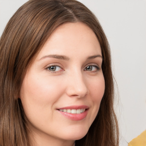 Joyful white young-adult female with long  brown hair and grey eyes