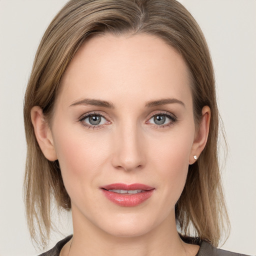 Joyful white young-adult female with medium  brown hair and grey eyes