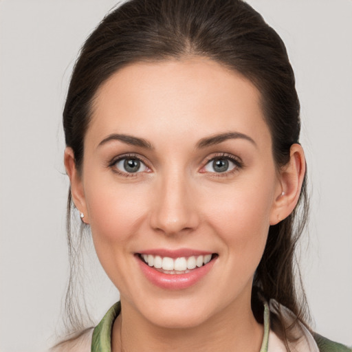 Joyful white young-adult female with medium  brown hair and grey eyes