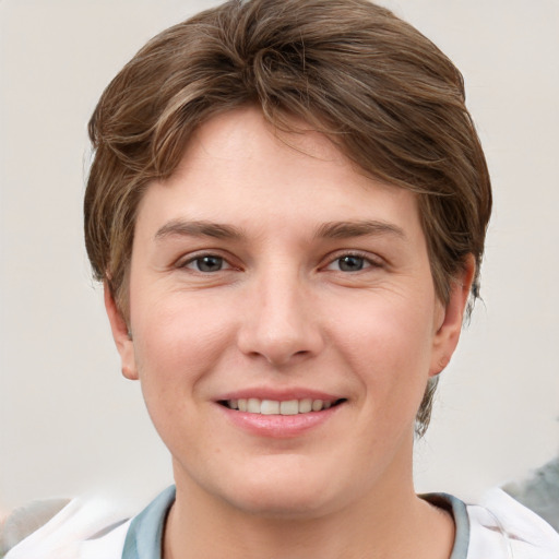 Joyful white young-adult female with short  brown hair and grey eyes