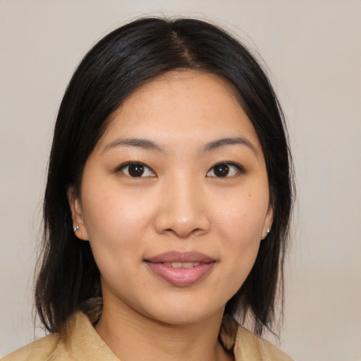 Joyful asian young-adult female with medium  brown hair and brown eyes