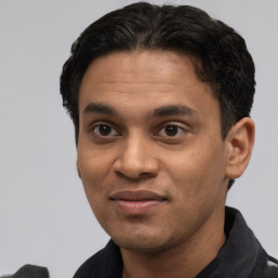 Joyful latino young-adult male with short  black hair and brown eyes