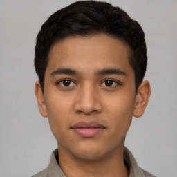 Joyful latino young-adult male with short  brown hair and brown eyes