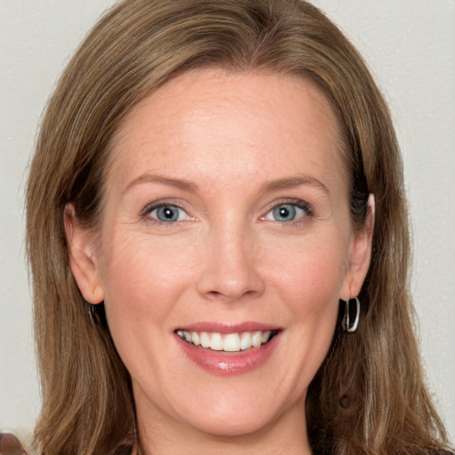 Joyful white young-adult female with long  brown hair and blue eyes