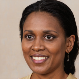 Joyful black adult female with medium  brown hair and brown eyes