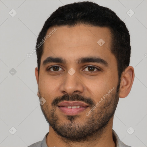 Joyful latino young-adult male with short  black hair and brown eyes