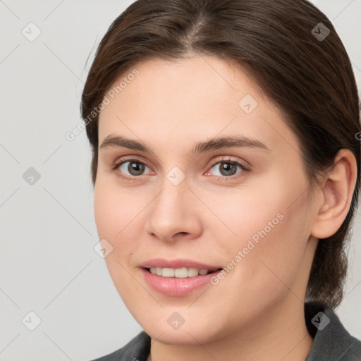 Joyful white young-adult female with medium  brown hair and grey eyes