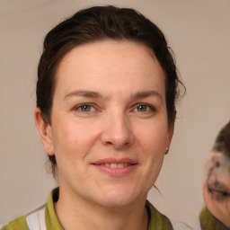 Joyful white adult female with medium  brown hair and grey eyes