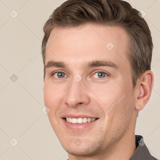 Joyful white young-adult male with short  brown hair and grey eyes