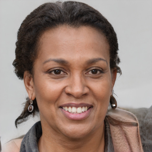 Joyful latino adult female with medium  brown hair and brown eyes