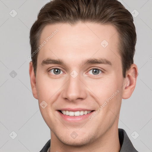 Joyful white young-adult male with short  brown hair and grey eyes