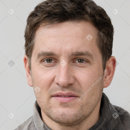 Joyful white adult male with short  brown hair and grey eyes