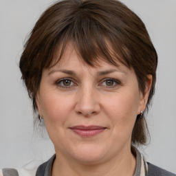 Joyful white adult female with medium  brown hair and grey eyes